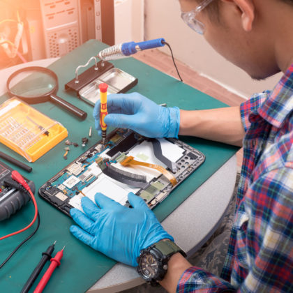 The abstract image of the asian technician repairing a tablet by
